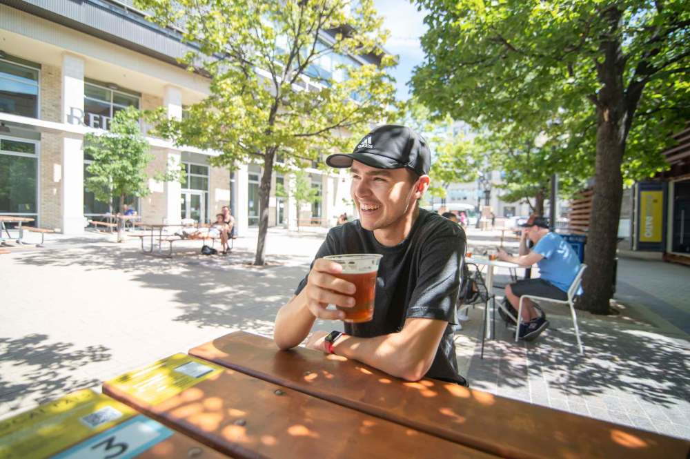 On Thursday, the City of Winnipeg announced it will provide an expedited process to grant temporary patio permits, enjoyed by Graham McCallum (pictured) and others last summer, to help businesses offset pandemic losses. Once approved, businesses would be able to operate outdoor dining sites from April 1 to Oct. 31. (Mike Sudoma / Winnipeg Free Press files)