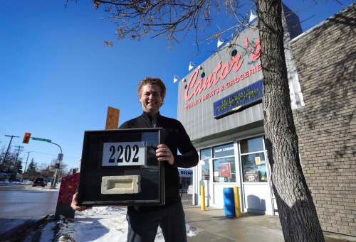 Ed Cantor, owner of Cantor&rsquo;s Quality Meats and Groceries, outside his Logan Avenue store with a brick from the first location of the family business started by his grandfather. (Ruth Bonneville / Winnipeg Free Press)