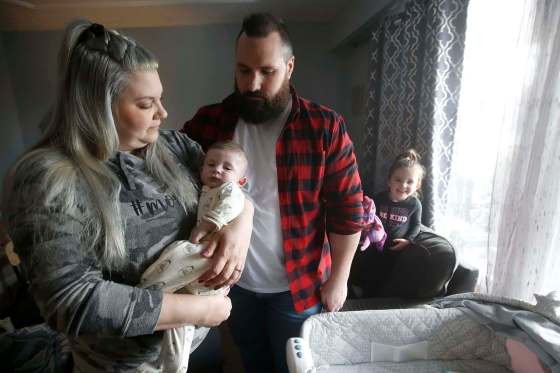 JOHN WOODS / WINNIPEG FREE PRESSAshleigh McMullen holds Lachlan, 4 months, as her husband, Rob, looks on and Hayleigh, 2, smiles at right. McMullen say she found it ‘traumatic’ that she had to go through the prenatal process alone as her husband wasn’t allowed to attend prenatal appointments.