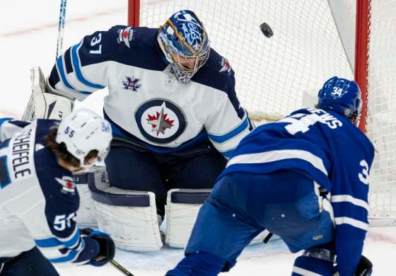 Toronto Maple Leafs centre Auston Matthews gets past Winnipeg Jets centre Mark Scheifele to score the game-winning goal on goaltender Connor Hellebuyck during overtime action in Toronto on Thursday. THE CANADIAN PRESS/Frank Gunn