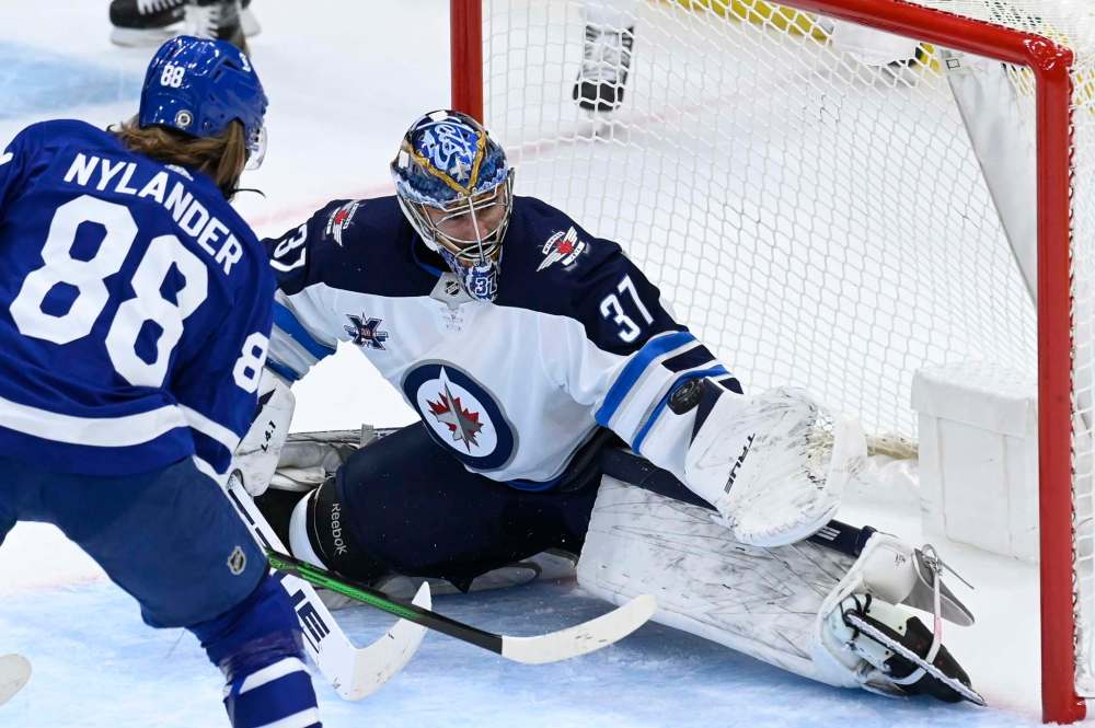 Winnipeg Jets goaltender Connor Hellebuyck (37) stops Toronto Maple Leafs centre William Nylander (88) during second period NHL action in Toronto on Thursday, March 11, 2021. THE CANADIAN PRESS/Frank Gunn