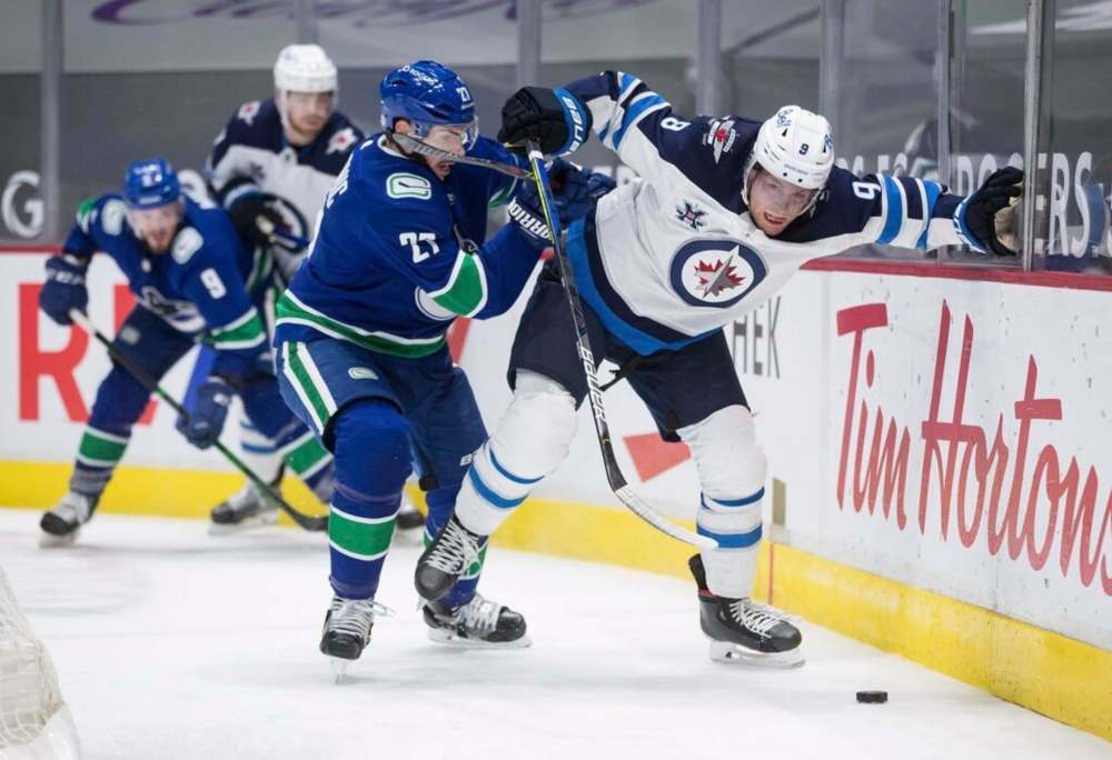 Vancouver Canucks' Travis Hamonic checks Winnipeg Jets' Andrew Copp during the third period in Vancouver, on Wednesday. Copp had a breakout performance with a career-high four goals in the game but despite the success, the 26-year-old says he has