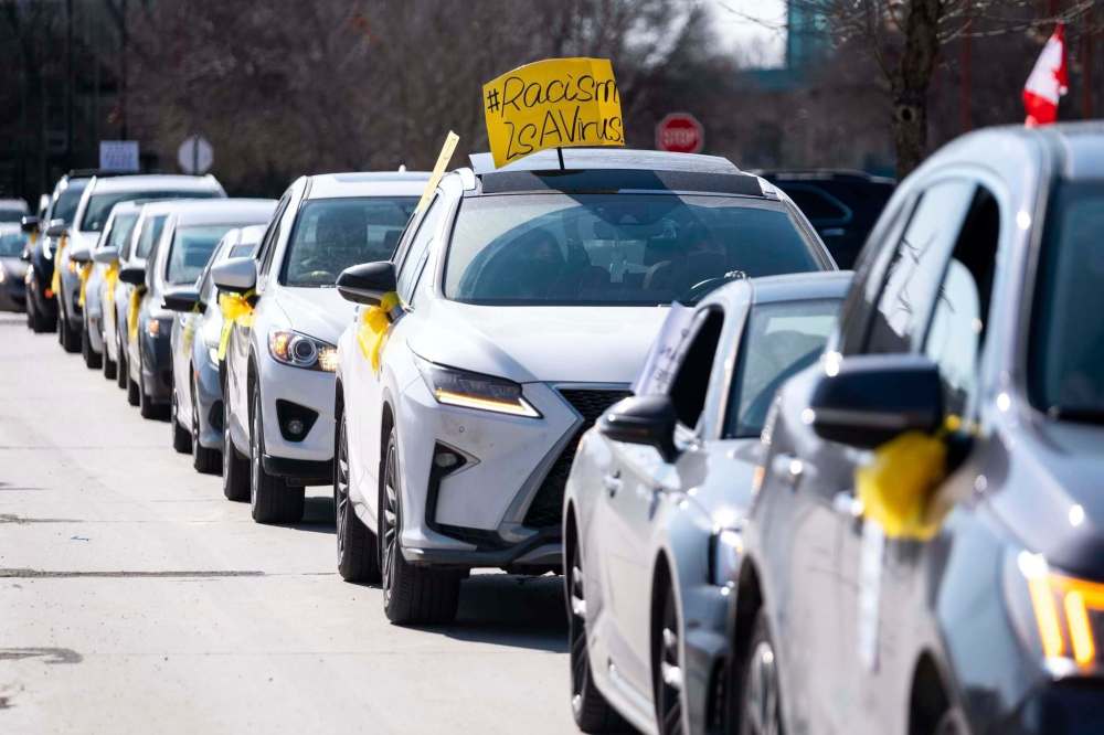While most people circled Israel Asper Way and Waterfront Drive in vehicles, some also lined the sidewalks with signs. Almost everyone carried a yellow ribbon. (Daniel Crump / Winnipeg Free Press)