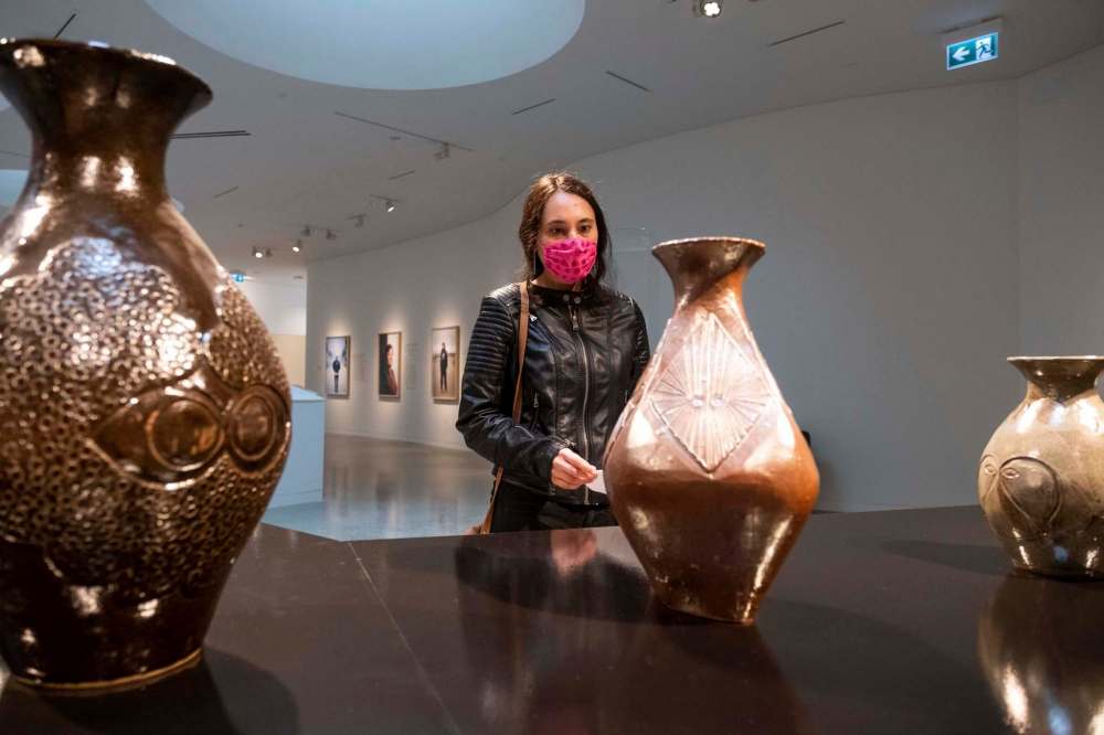 Nikki Tomoniko takes in some of the pottery on display at the centre. (Daniel Crump / Winnipeg Free Press)