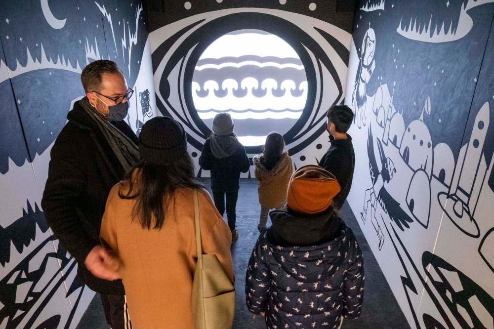 James and Anne-Marie Moore explore a mixed medium art installation with their children at Qaumajuq, the newly opened Inuit art centre at the Winnipeg Art Gallery Saturday. (Daniel Crump / Winnipeg Free Press)