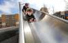 RUTH BONNEVILLE / WINNIPEG FREE PRESS
One-year-old Joseph is all smiles as he slides with his dad, Ryan, down the slide at Central Park. Families enjoyed the downtown park on Monday &mdash; two days after a Saturday shooting.