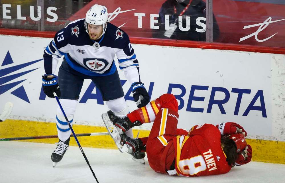 Jeff McIntosh / The Canadian Press
Pierre-Luc Dubois, left, checks Calgary Flames' Chris Tanev during the first period.