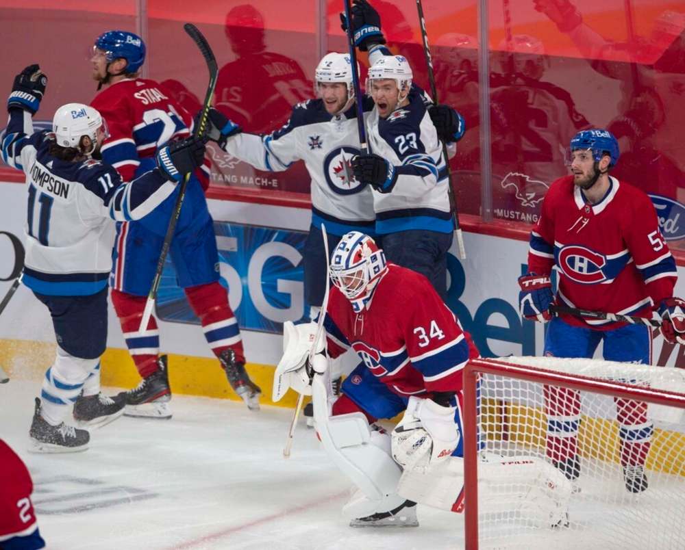 Winnipeg Jets centre Trevor Lewis celebrates his goal with teammates Jansen Harkins and Nate Thompson during the first period Thursday in Montreal. THE CANADIAN PRESS/Ryan Remiorz