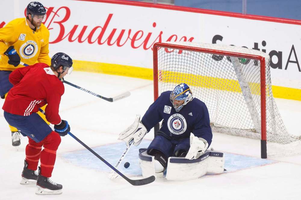 MIKE DEAL / WINNIPEG FREE PRESS
Jets goalie Connor Hellebuyck makes a save Tuesday at practice. Hellebuyck's teammates are not pointing the finger at their world-class goalie for the club's recent slide.