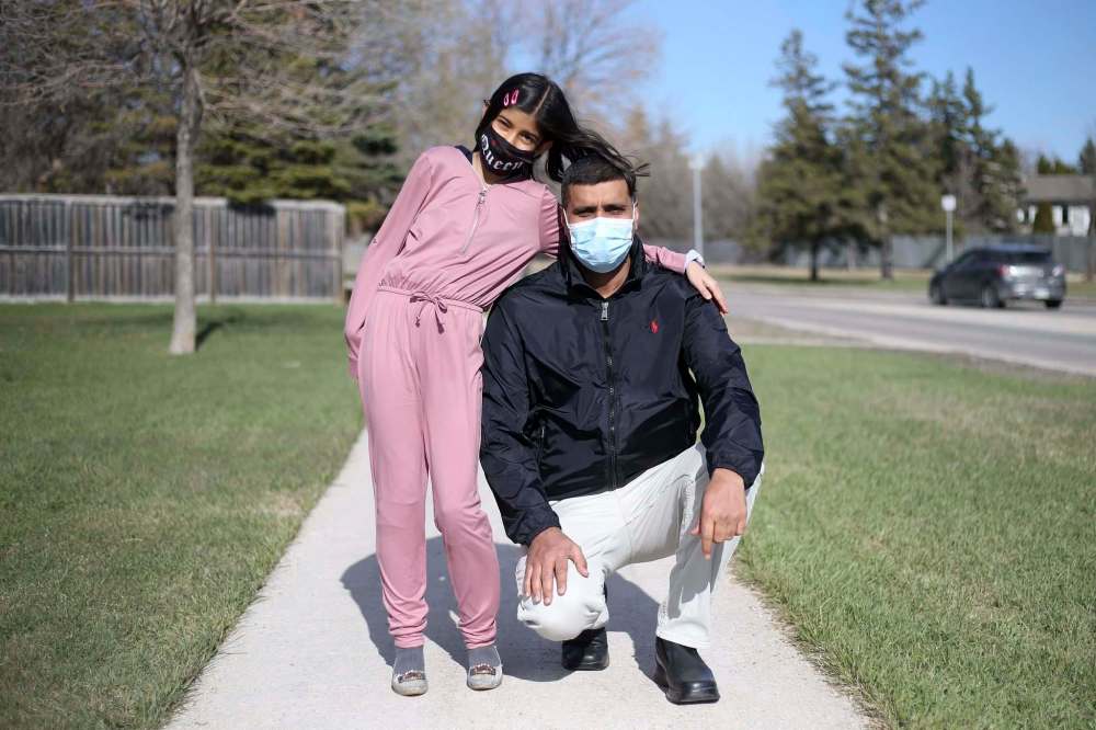 SHANNON VANRAES / WINNIPEG FREE PRESS
Zahid Abbas, with daughter Kashaf, was thrilled to be able to tell her the good news.