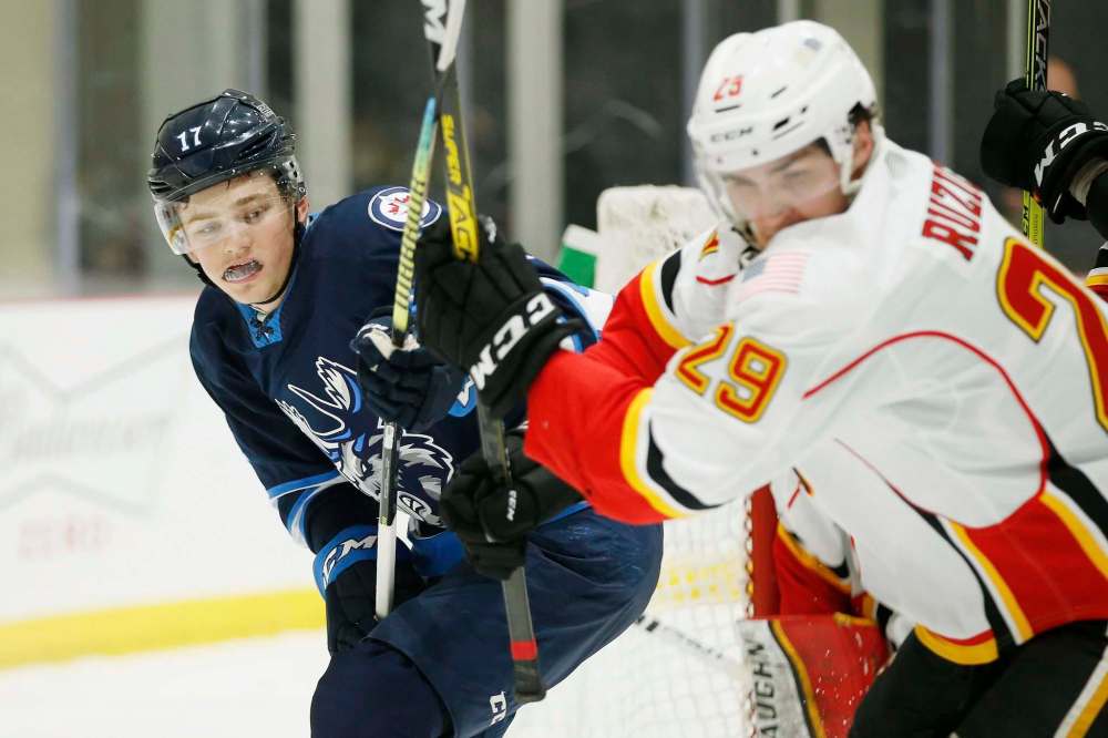 JOHN WOODS / WINNIPEG FREE PRESS
Cole Perfetti skates against the Stockton Heat’s Adam Ruzicka during the first period in Winnipeg on Thursday.