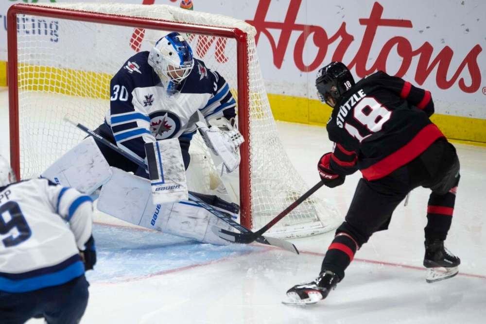 Winnipeg Jets goaltender Laurent Brossoit makes a pad save on Ottawa Senators left wing Tim Stützle during the third period in Ottawa, Monday. THE CANADIAN PRESS/Adrian Wyld
