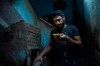 In this May 9, 2020 photo, 28-year-old football defender Mahrous Mahmoud, stops to look at his phone as he walks down the stairs of the building where he lives, in Manfalut, a town 350 kilometers (230 miles) south of Cairo in the province of Assiut, Egypt. Mahmoud should be on the field at this time of year playing as a defender for Beni Suef, a club in Egypt's second division. But like millions in the Arab world's most populous country, he has been hit hard by the coronavirus pandemic. (AP Photo/Nariman El-Mofty)