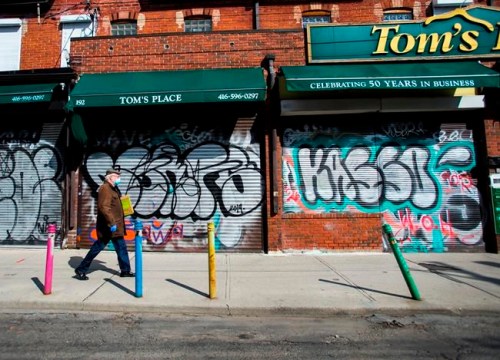 A lone person walks past closed businesses in Kensington Market in Toronto on Wednesday, April 15, 2020. Prime Minister Justin Trudeau says the federal government is expanding a loan program for small businesses suffering from the COVID-19 pandemic and is working on a new support for companies having trouble paying rent.THE CANADIAN PRESS/Nathan Denette