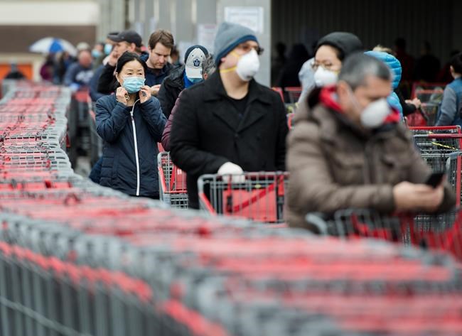 Hundreds of people wait in line to enter Costco in Toronto on Monday, April 13, 2020. Health officials and the government have asked that people stay inside to help curb the spread of COVID-19. THE CANADIAN PRESS/Nathan Denette