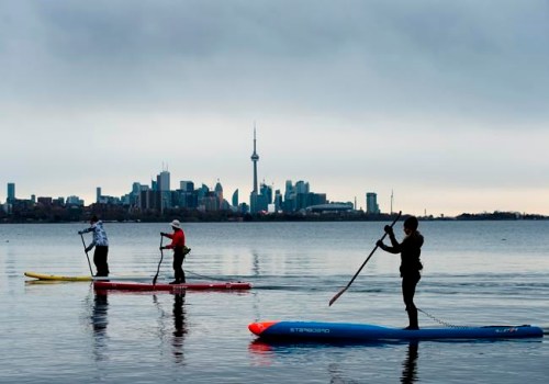 People physical distance while stand-up paddleboarding in Humber Bay on Lake Ontario during the COVID-19 pandemic in Toronto on Sunday, May 10, 2020. THE CANADIAN PRESS/Nathan Denette