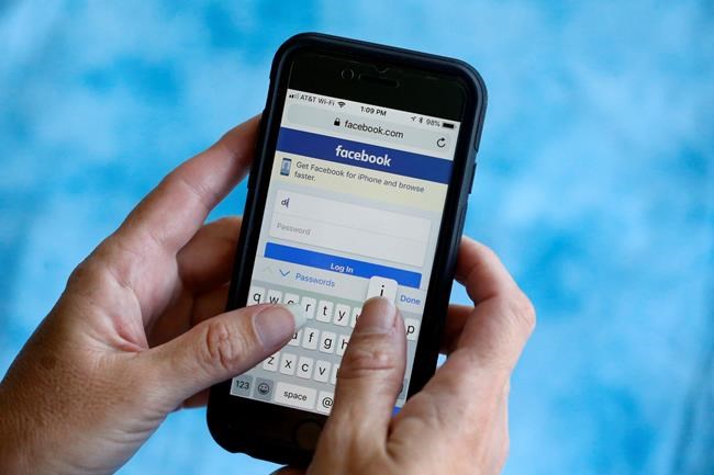 FILE - In this Aug. 21, 2018, file photo, a Facebook start page is shown on a smartphone in Surfside, Fla. Facebook says it's working to help limit the spread of misinformation and harmful content about the coronavirus and will focus on providing helpful information to people. Kang-Xing Jin, Facebook's head of health, said in a post, Friday, Jan. 31, 2020, that the social media platform's third-party fact-checkers are reviewing content and debunking false claims related to the coronavirus. (AP Photo/Wilfredo Lee, File)