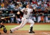 FILE - In this Friday, May 17, 2019, file photo, San Francisco Giants' Buster Posey watches the flight of his fly ball against the Arizona Diamondbacks during the third inning of a baseball game, in Phoenix. Posey is the latest big-name player to skip this season because of concerns over the coronavirus pandemic. Posey announced his decision on Friday, July 10, 2020. He says his family finalized the adoption of identical twin girls this week. The babies were born prematurely and Posey said after consultations with his wife and doctor he decided to opt out of the season.(AP Photo/Ralph Freso, File)
