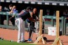 FILE - In this July 5, 2020, file photo, Atlanta Braves' Nick Markakis, right, talks with a coach during team practice at Truist Park in Atlanta. Braves outfielder Nick Markakis has opted out of the 2020 season. The 36-year-old Markakis said he was uneasy about playing the season without fans and then was swayed by his telephone conversation with teammate Freddie Freeman, who has tested positive for COVID-19 and has fever and other symptoms. (AP Photo/Brynn Anderson, File)