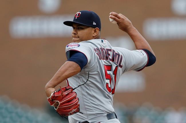 FILE - In this Sunday, Sept. 1, 2019 file photo, Minnesota Twins relief pitcher Brusdar Graterol throws his first MLB pitch during the ninth inning of a baseball game against the Detroit Tigers in Detroit. With less than a week before pitchers and catchers were scheduled to report to spring training, the Red Sox sent Mookie Betts and David Price to the Los Angeles Dodgers in a deal that brought outfielder Alex Verdugo and Twins pitching prospect Brusdar Graterol to Boston. (AP Photo/Carlos Osorio, File)