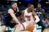 FILE - In this Feb. 1, 2020, file photo, Miami Heat forward Bam Adebayo (13) tries to get around Orlando Magic center Nikola Vucevic, left, and guard Terrence Ross (31) during the first half of an NBA basketball game in Orlando, Fla. Reporters from The Associated Press spoke to more than two dozen athletes from around the globe -- representing seven countries and 11 sports -- to get a sense of how concerned or confident they are about resuming competition. What emerged, above all, was a sense that they are going through the very same sort of calculus that much of the rest of society is: What is safe nowadays? (AP Photo/John Raoux, File)