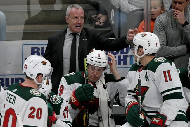 FILE - In this Sunday, March 8, 2020, file photo, Minnesota Wild interim head coach Dean Evason, above center, directs players behind the bench during the overtime period of an NHL hockey game against the Anaheim Ducks in Anaheim, Calif. The Minnesota Wild made Dean Evason their full-time head coach on Monday, July 13, 2020, signing him to a two-year contract extension at the commencement of training camp for the restarted NHL season.(AP Photo/Alex Gallardo, File)