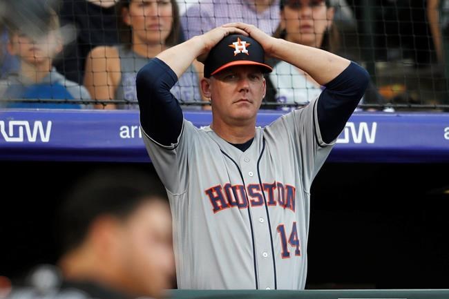FILE - In this July 2, 2019, file photo, Houston Astros manager AJ Hinch reacts during a baseball game against the Colorado Rockies, in Denver. Houston manager AJ Hinch and general manager Jeff Luhnow were suspended for the entire season Monday, Jan. 13, 2020, and the team was fined $5 million for sign-stealing by the team in 2017 and 2018 season. Commissioner Rob Manfred announced the discipline and strongly hinted that current Boston manager Alex Cora — the Astros bench coach in 2017 — will face punishment later. Manfred said Cora developed the sign-stealing system used by the Astros. (AP Photo/David Zalubowski, File)