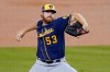 FILE - Milwaukee Brewers starting pitcher Brandon Woodruff winds up during the second inning in Game 2 of the team's National League wild-card baseball series against the Los Angeles Dodgers in Los Angeles, in this Thursday, Oct. 1, 2020, file photo. Woodruff is providing stability and stopping he Milwaukee Brewers’ revolving door of opening-day starting pitchers. Milwaukee manager Craig Counsell announced Thursday, March 18, 2021, that Woodruff will start the Brewers’ season opener for a second straight year. (AP Photo/Ashley Landis)