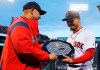 FILE - In this April 11, 2019, file photo, Boston Red Sox manager Alex Cora, left, presents right fielder Mookie Betts with the 2018 AL MVP Award before a baseball game between the Red Sox and the Toronto Blue Jays at Fenway Park in Boston. The award includes the name and image of Kenesaw Mountain Landis. (AP Photo/Winslow Townson, File)