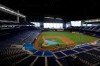 FILE - This is a July 4, 2020, file photo showing the Miami Marlins running drills during a baseball workout at Marlins Park in Miami. Marlins Park will have a new look for its 2020 season debut Friday, thanks to cozier dimensions and a switch to artificial turf. Also, the home team is in first place. (AP Photo/Wilfredo Lee, File)