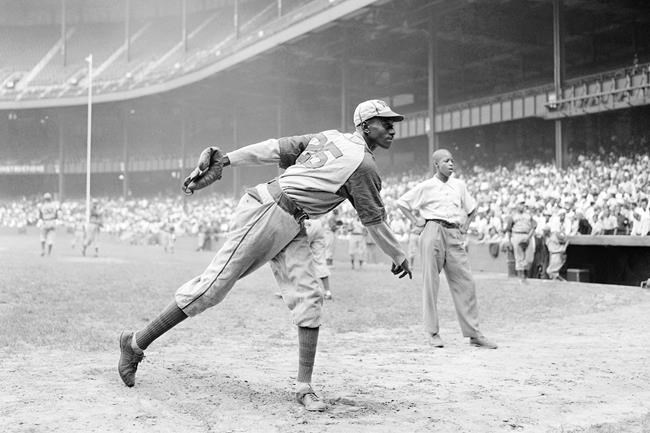 FILE - In this Aug. 2, 1942, file photo, Kansas City Monarchs pitcher Leroy Satchel Paige warms up at New York's Yankee Stadium before a Negro League game between the Monarchs and the New York Cuban Stars. Major League Baseball has reclassified the Negro Leagues as a major league and will count the statistics and records of its 3,400 players as part of its history. The league said Wednesday, Dec. 16, 2020, it was