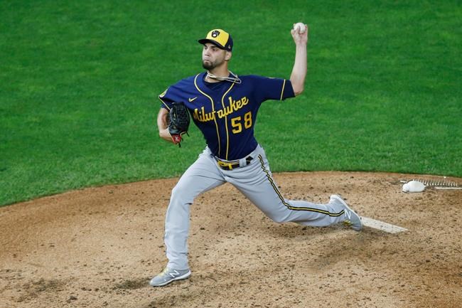 Milwaukee Brewers' pitcher Alex Claudio throws against the Minnesota Twins during a baseball game in Minneapolis, Tuesday, Aug. 18, 2020. Left-handed reliever Alex Claudio has agreed to a one-year, $1.125 million contract with the Los Angeles Angels. The Angels announced the deal Wednesday, Dec. 16, 2020.(AP Photo/Jim Mone)
