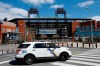 FILE - In this March 24, 2020, file photo, a Police vehicle blocks a street near Citizens Bank Park, home of the Philadelphia Phillies baseball team, in Philadelphia. On MLB’s opening day, ballparks will be empty with the start of the season on hold because of the coronavirus pandemic. (AP Photo/Matt Slocum, File)