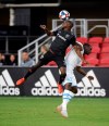 FILE - In this July 24, 2019, file photo, D.C. United defender Chris Odoi-Atsem, left, heads the ball against Marseille midfielder Niels Nkounkou, right, during the first half of an international friendly soccer match in Washington. When the MLS Is Back tournament starts next week in Florida, the vast majority of the league’s players will be taking part. For some, that includes balancing their own personal underlying health concerns with the opportunity to return to their profession. hat includes the likes of Columbus goalkeeper Matt Lampson and D.C. United's Chris Odoi-Atsem, who have both overcome cancer.(AP Photo/Nick Wass, File)