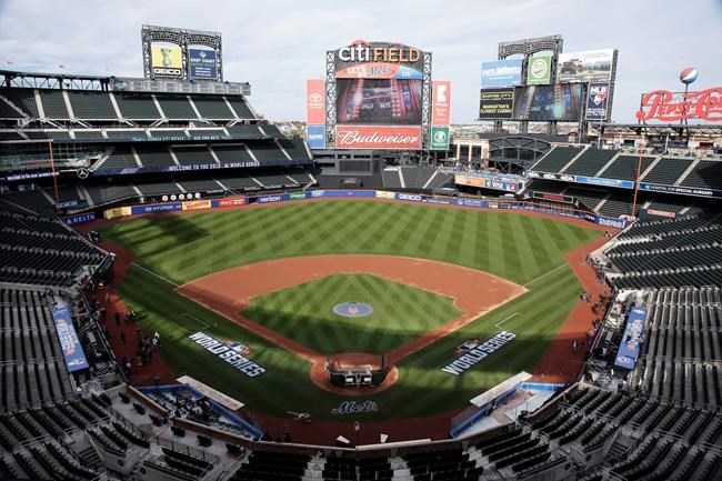 FILE - In this Oct. 29, 2015, file photo, members of the media and grounds crew work on the field at Citi Field in New York, the day before Game 3 of the World Series between the Mets and the Kansas City Royals at the stadium. Baseball Commissioner Rob Manfred says talks have ended over the proposed sale of a controlling share of the Mets from the families of Fred Wilpon and Saul Katz to hedge fund manager Steven Cohen. (AP Photo/Peter Morgan, File)