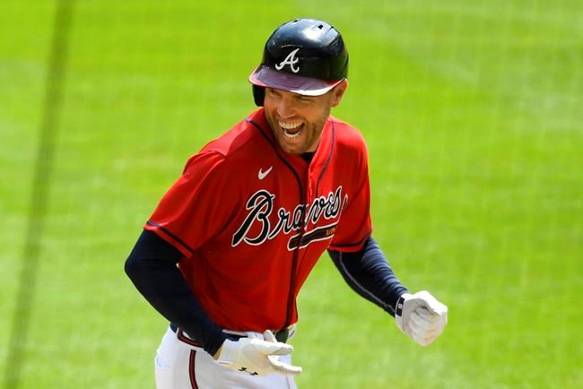 FILE - Atlanta Braves' Freddie Freeman reacts as he runs along the third base line after hitting a grand slam home run in the sixth inning of a baseball game against the Washington Nationals in Atlanta, in this Sunday, Sept. 6, 2020, file photo. NL MVP Freddie Freeman has followed his big season with the Atlanta Braves with an even more memorable offseason. He and his wife have two baby boys, including one from a surrogate mother. He calls his new babies his “twins with a twist.”(AP Photo/John Amis, File)
