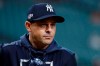 FILE - In this Saturday, Oct. 19, 2019 file photo, New York Yankees manager Aaron Boone watches batting practice before Game 6 of baseball's American League Championship Series against the Houston Astros in Houston. One year later, there's a better understanding of what it takes to play a baseball season amid a pandemic. Pitchers and catchers reported to spring training Wednesday, Feb. 17, 2021. (AP Photo/Matt Slocum, File)