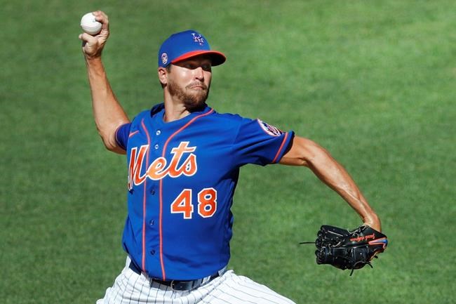 FILE - In this July 9, 2020, file photo, New York Mets starting pitcher Jacob deGrom winds up while delivering during a simulated baseball game, part of the Mets summer training camp workout, at Citi Field in New York. Pete Alonso at the plate. Jacob deGrom on the mound. And a healthy Yoenis Céspedes pegged conveniently for designated hitter. There’s no question the New York Mets have reasons to believe this pandemic-shortened season is perfect for them -- even without injured starter Noah Syndergaard. All they need to do is pick right up where they left off last year.(AP Photo/Kathy Willens, File)