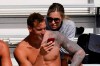 FILE - In this April 10, 2021, file photo, Caeleb Dressel, left, and his wife, Meghan Dressel, look at a phone in the stands before the TYR Pro Swim Series swim meet in Mission Viejo, Calif. For a man tabbed as swimming’s next superstar, Dressel could not be more disinterested. Of course, he cares about being fast in the pool. He just is not into anyone else’s expectations or comparisons. Fame is not his thing, either. (AP Photo/Ashley Landis, File)