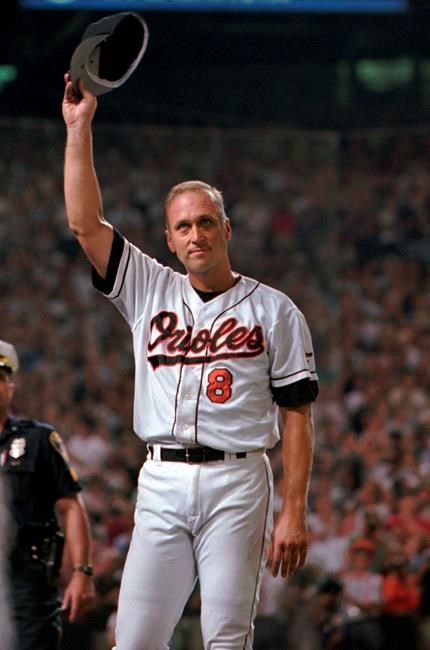 FILE - In this Sept. 6, 1995, file photo, Baltimore Orioles' Cal Ripken Jr. tips his cap to the crowd in the middle of the fifth inning when the baseball game against the California Angels became official and he officially broke Lou Gehrig's record of 2,130 consecutive games in Baltimore's Camden Yards. It has been 25 years since Ripken broke Gehrig's major league record for consecutive games played, a feat the Orioles star punctuated with an unforgettable lap around Camden Yards in the middle of his 2,131st successive start. (AP Photo/Roberto Borea, File)