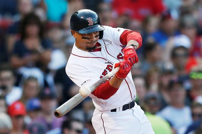 FILE - In this Aug. 10, 2019, file photo, Boston Red Sox's Mookie Betts hits an RBI-double during the sixth inning of a baseball game against the Los Angeles Angels in Boston. Betts has agreed to a $27 million contract with the Red Sox. It is the largest one-year salary for an arbitration-eligible player. (AP Photo/Michael Dwyer, File)
