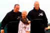 FILE - In this June 18, 2002, file photo, Cal Ripken Jr., right, owner of the Aberdeen IronBirds, and his brother, Bill, walk off the field with their mother, Vi, after she threw out the ceremonial first pitch prior to the team's season-opening debut at the new Ripken Stadium in Aberdeen, Md. Vi, matriarch of the famed Orioles family that includes Hall of Fame son Cal Jr. and once the victim of a bizarre kidnapping, has died. She was 82. Family spokesman John Maroon said she died Friday, Feb. 26, 2021, a day before her birthday. (AP Photo/Roberto Borea, File)