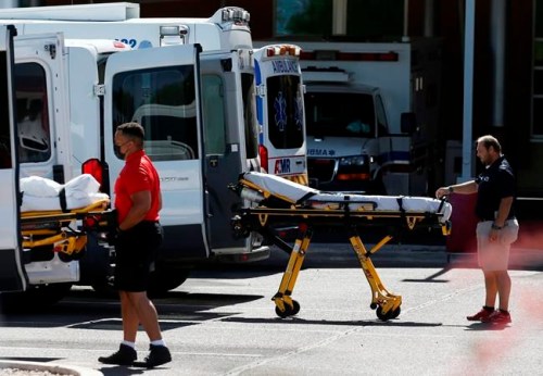 FILE - In this June 16, 2020, file photo, medical transports and ambulances are parked outside the emergency-room entrance at Banner Desert Medical Center, in Mesa, Ariz. The number of deaths per day from the coronavirus in the U.S. has fallen in recent weeks to the lowest level since late March, even as states increasingly reopen for business. But scientists are deeply afraid the trend may be about to reverse itself. (AP Photo/Ross D. Franklin, File)