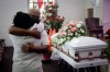 FILE - In this July 21, 2020, file photo, Darryl Hutchinson, facing camera, is hugged by a relative during a funeral service for Lydia Nunez, who was Hutchinson's cousin at the Metropolitan Baptist Church in Los Angeles. Nunez died from COVID-19. The U.S. death toll from the coronavirus topped 300,000 Monday, Dec. 14, just as the country began dispensing COVID-19 shots in a monumental campaign to conquer the outbreak. (AP Photo/Marcio Jose Sanchez, File)