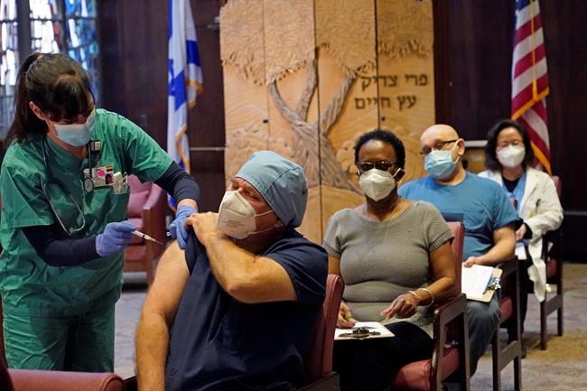 FILE - In this Dec. 30, 2020, file photo, nurse manager Rob Treiber receives a COVID-19 vaccine at Hebrew Rehabilitation Center in Boston. Nearly a year to the day after Wuhan went into lockdown to contain a virus that had already escaped, President Joe Biden began putting into effect a new war plan for fighting the outbreak in the United States, Germany topped 50,000 deaths, and Britain closed in on 100,000. (AP Photo/Elise Amendola, File)