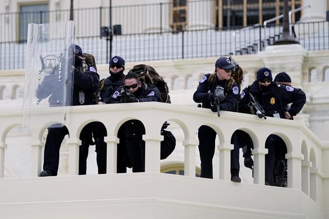 Police keep a watch on demonstrators who tried to break through a police barrier, Wednesday, Jan. 6, 2021, at the Capitol in Washington. (AP Photo/Julio Cortez)