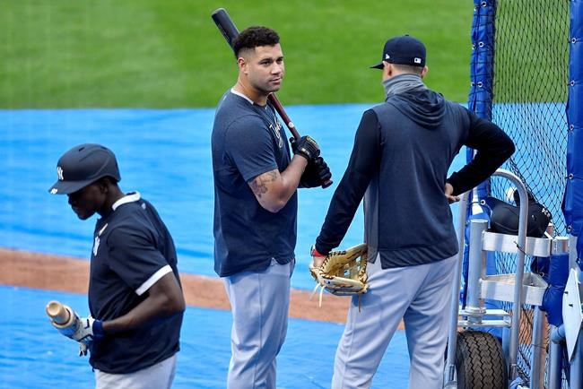 New York Yankees catcher Gary Sánchez, center, talks with manager Aaron Boone, right, during batting practice before a baseball game against the Toronto Blue Jays in Buffalo, N.Y., Monday, Sept. 7, 2020. (AP Photo/Adrian Kraus)