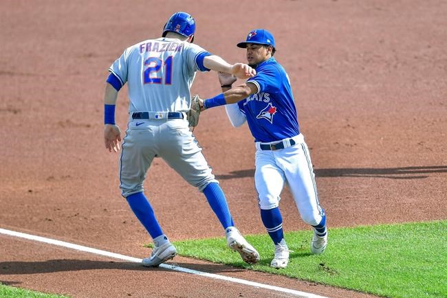Toronto Blue Jays shortstop Santiago Espinal, right, tags New York Mets' Todd Frazier for an out on a rundown during the first inning of a baseball game in Buffalo, N.Y., Sunday, Sept. 13, 2020. (AP Photo/Adrian Kraus)