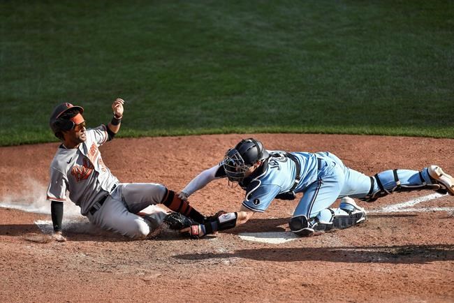 Toronto Blue Jays catcher Danny Jansen, right, tags out Baltimore Orioles' Mason Williams at home plate during the 10th inning of a baseball game in Buffalo, N.Y., Monday, Aug. 31, 2020. (AP Photo/Adrian Kraus)