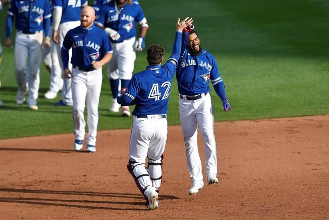 Toronto Blue Jays' Teoscar Hernández, right, celebrates with Danny Jansen after hitting a walk-off two-run single against the Baltimore Orioles during the ninth inning of a baseball game in Buffalo, N.Y., Sunday, Aug. 30, 2020. Toronto beat Baltimore 6-5. (AP Photo/Adrian Kraus)